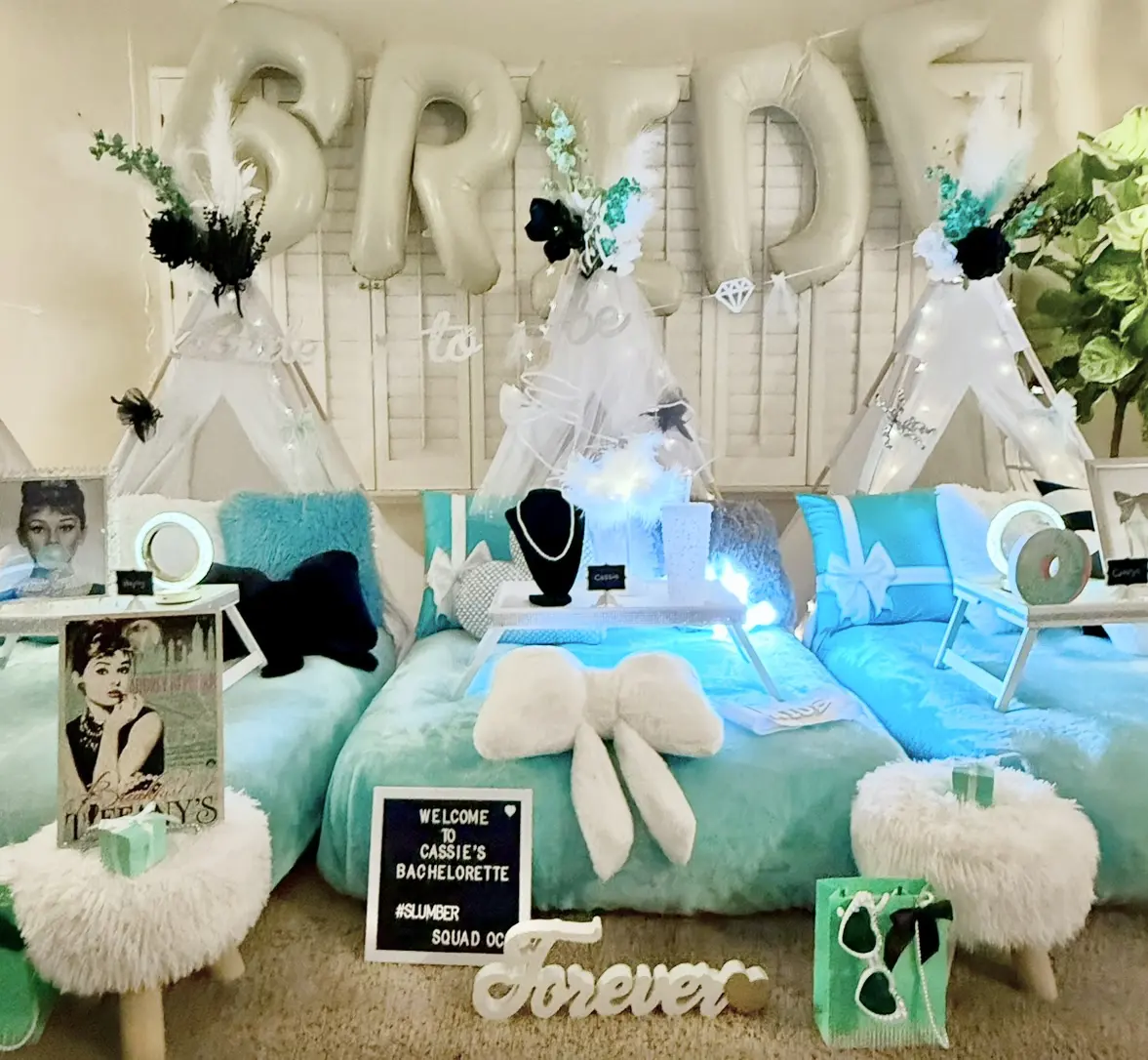 Teal bachelorette slumber party setup with teepees