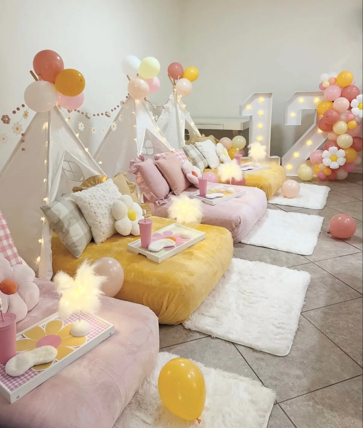 Pastel teepee sleepover party setup with balloons