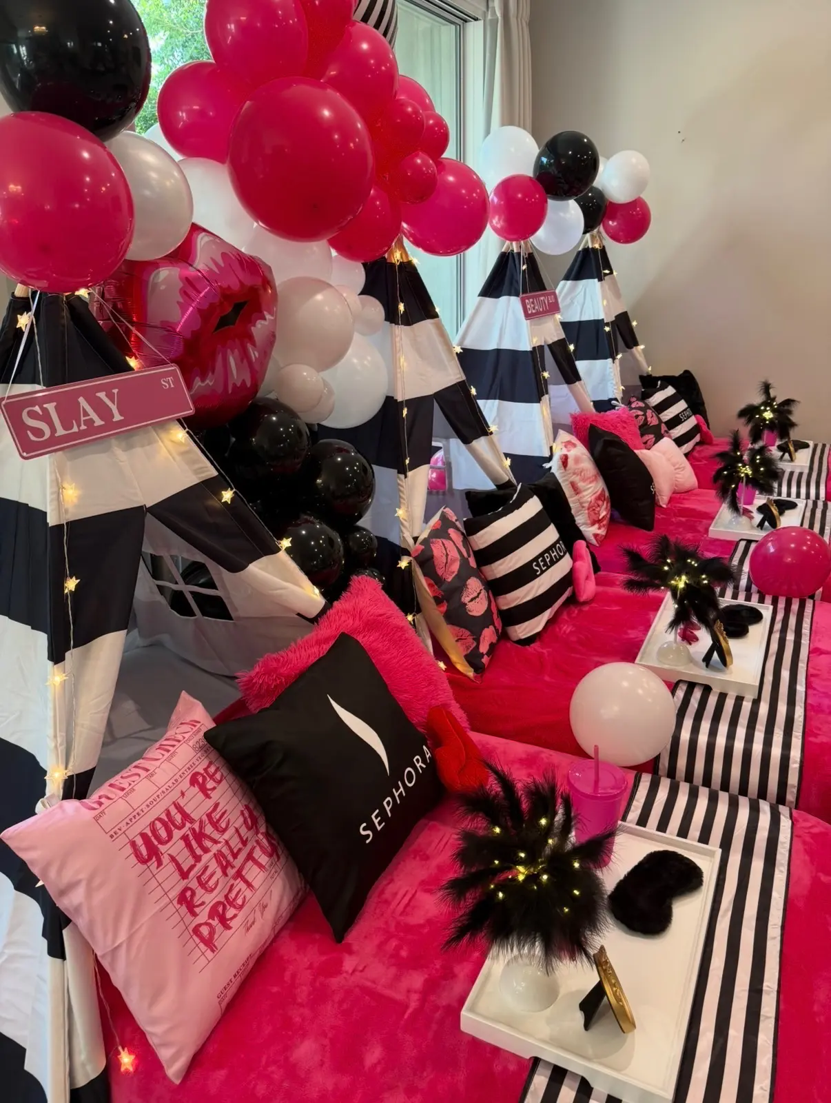 Sephora-themed pink and black sleepover teepee display
