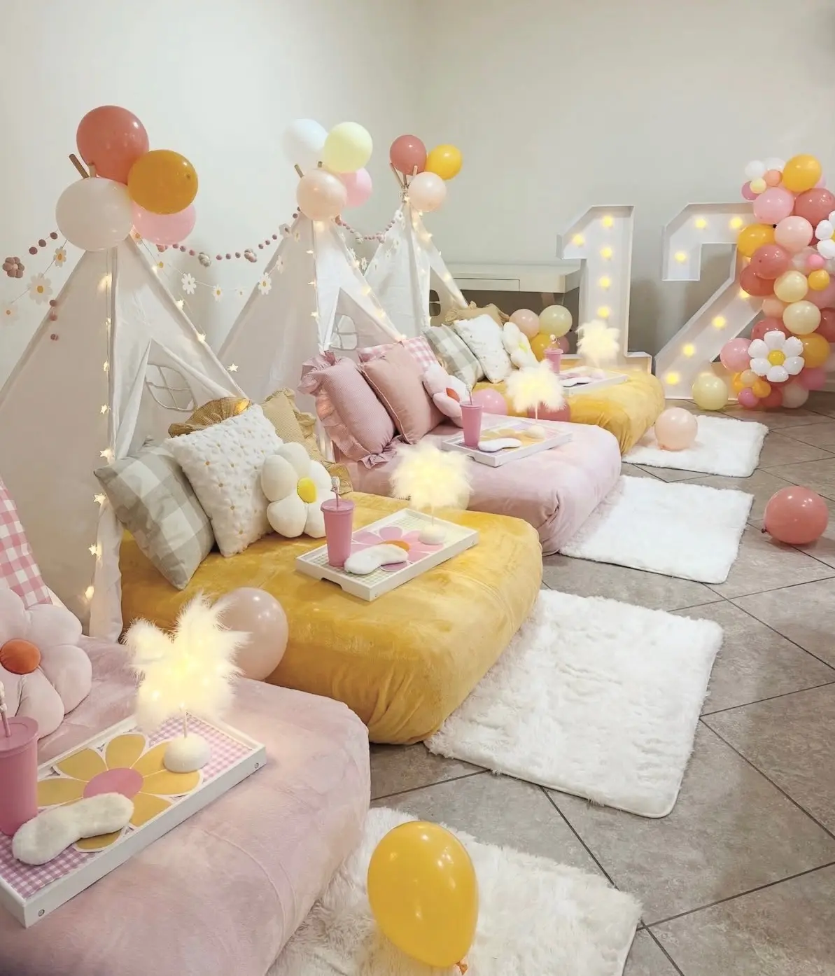 Pastel teepee sleepover setup with balloons