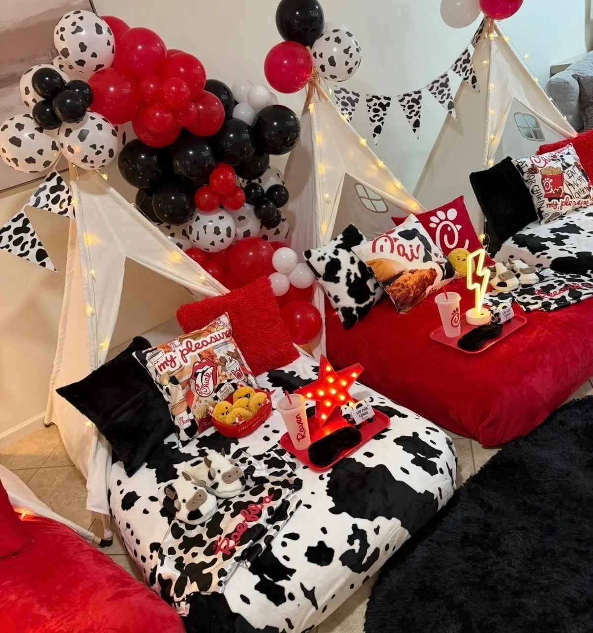 Cow-print sleepover tents with red balloons
