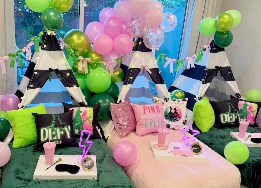 Pink and green balloon teepee sleepover setup