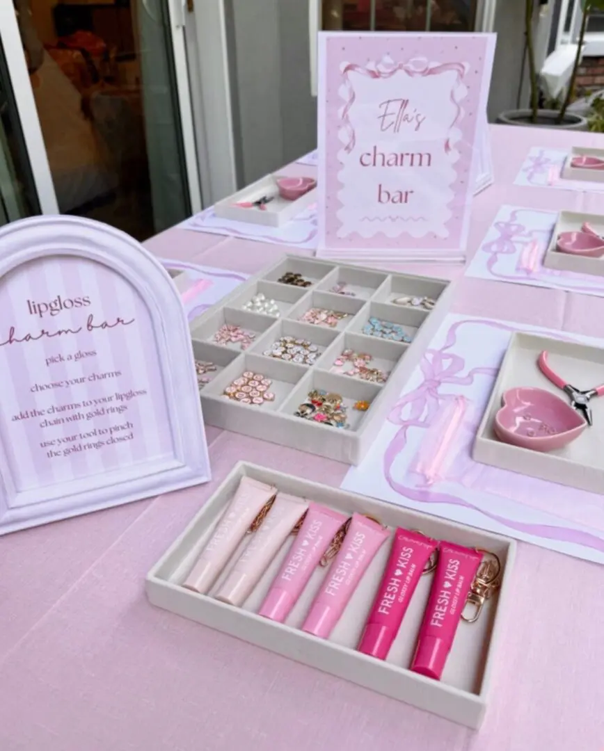 A pastel pink-themed display of cosmetics and accessories on a table.