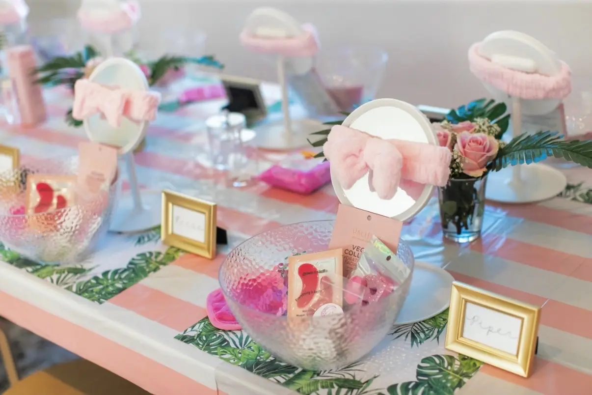 Elegant baby shower table setup with pink and white decorations.