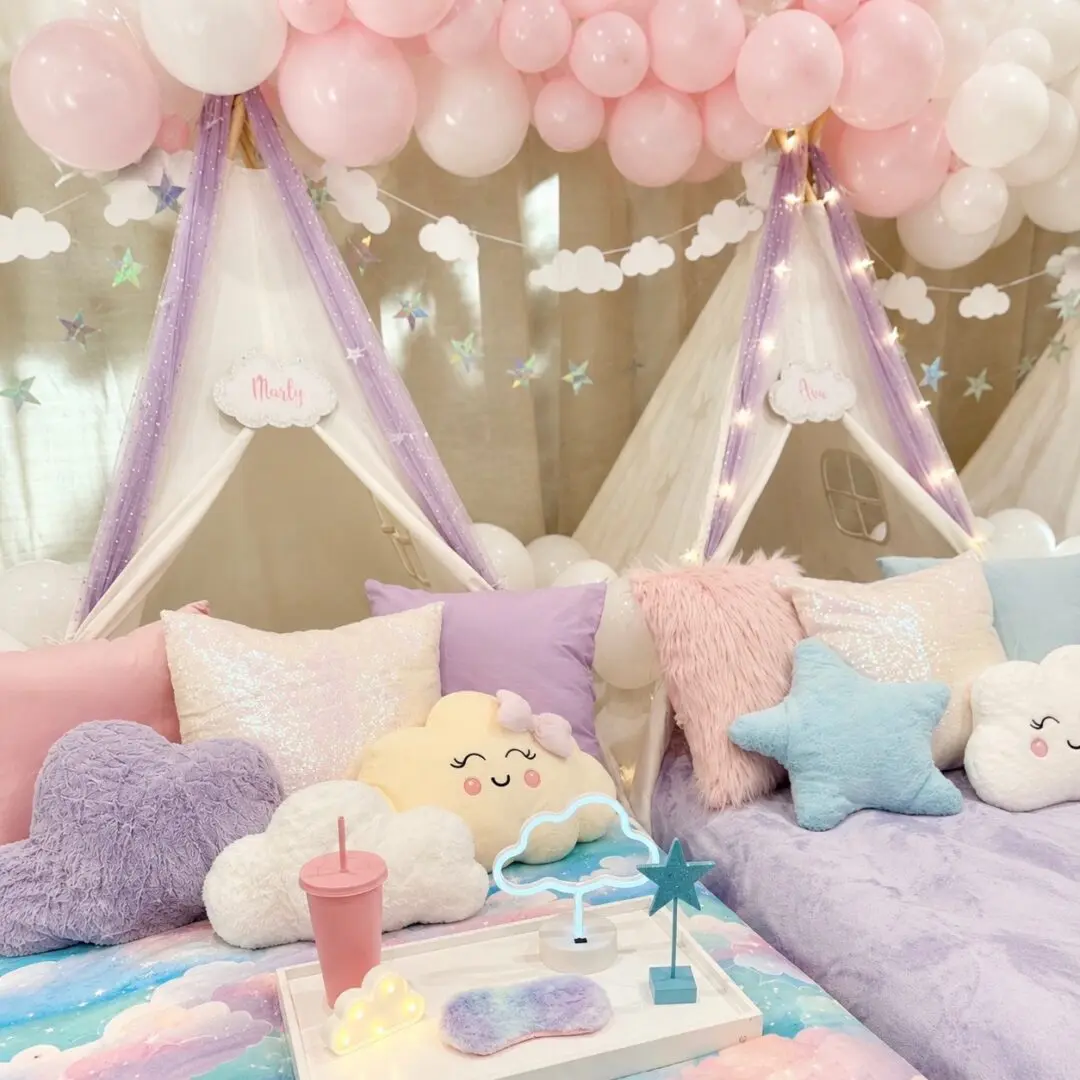 Pastel sleepover tents with balloons and cloud pillows