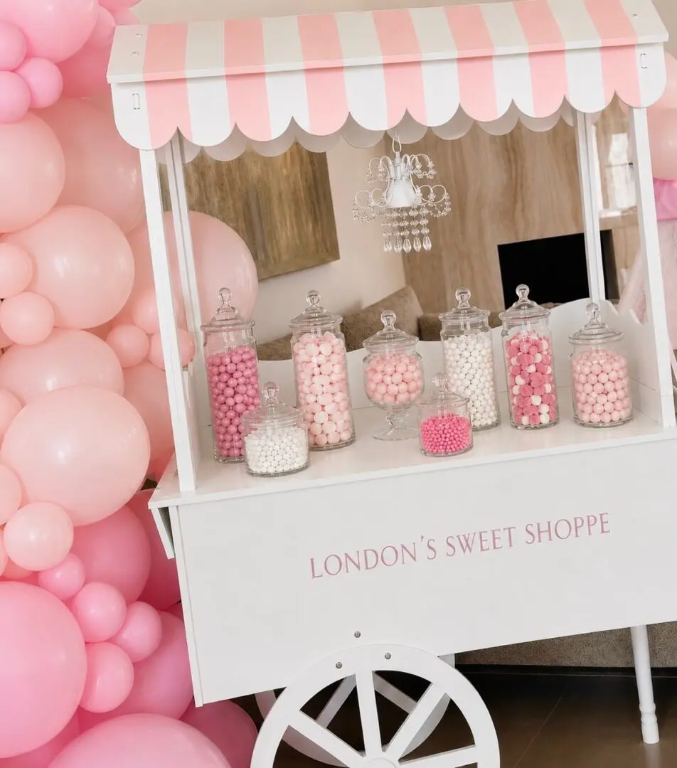 Pink candy cart with jars and balloons