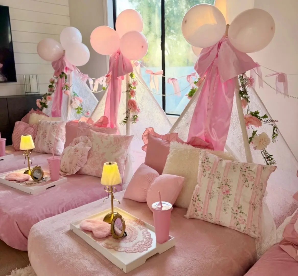 Pink teepee sleepover setup with balloons