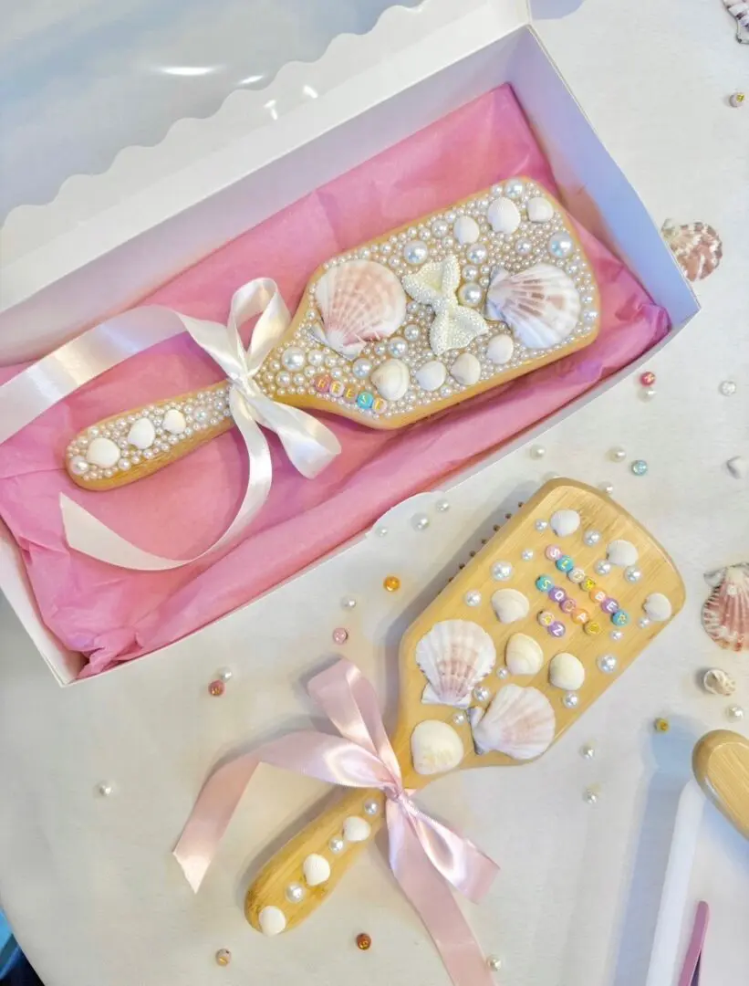 Seashell-decorated pearl hairbrushes with pink ribbons