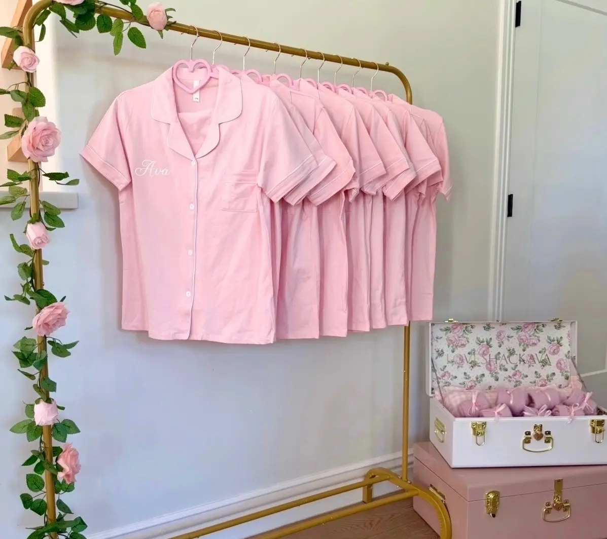 Pink pajama shirts hanging on gold rack