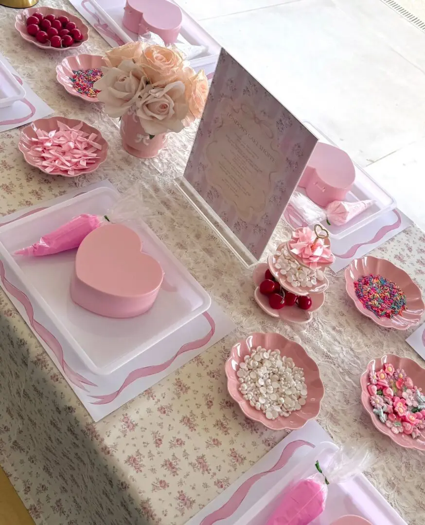 Pink heart-shaped party table with candies
