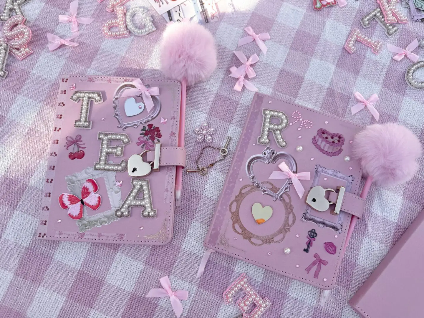 Two pink decorated journals with pom-poms