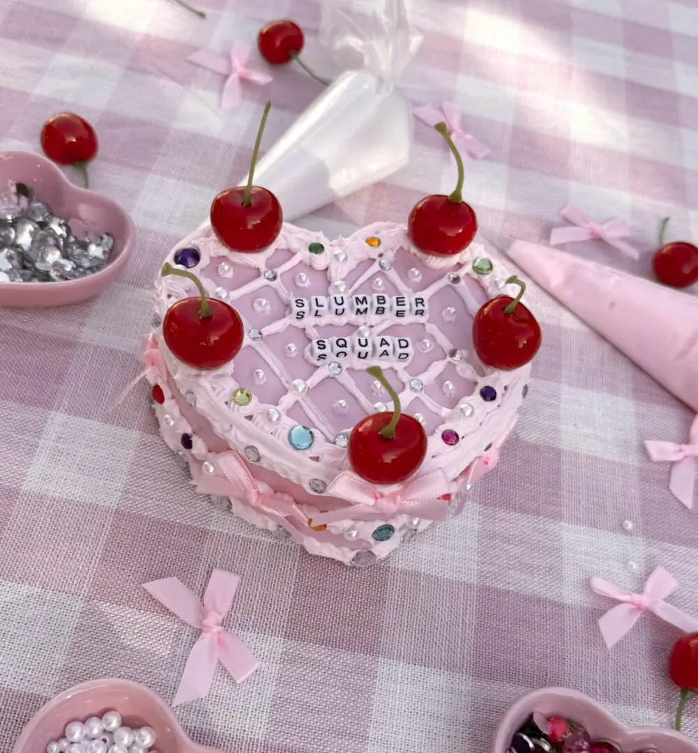 Pink heart-shaped cake topped with cherries