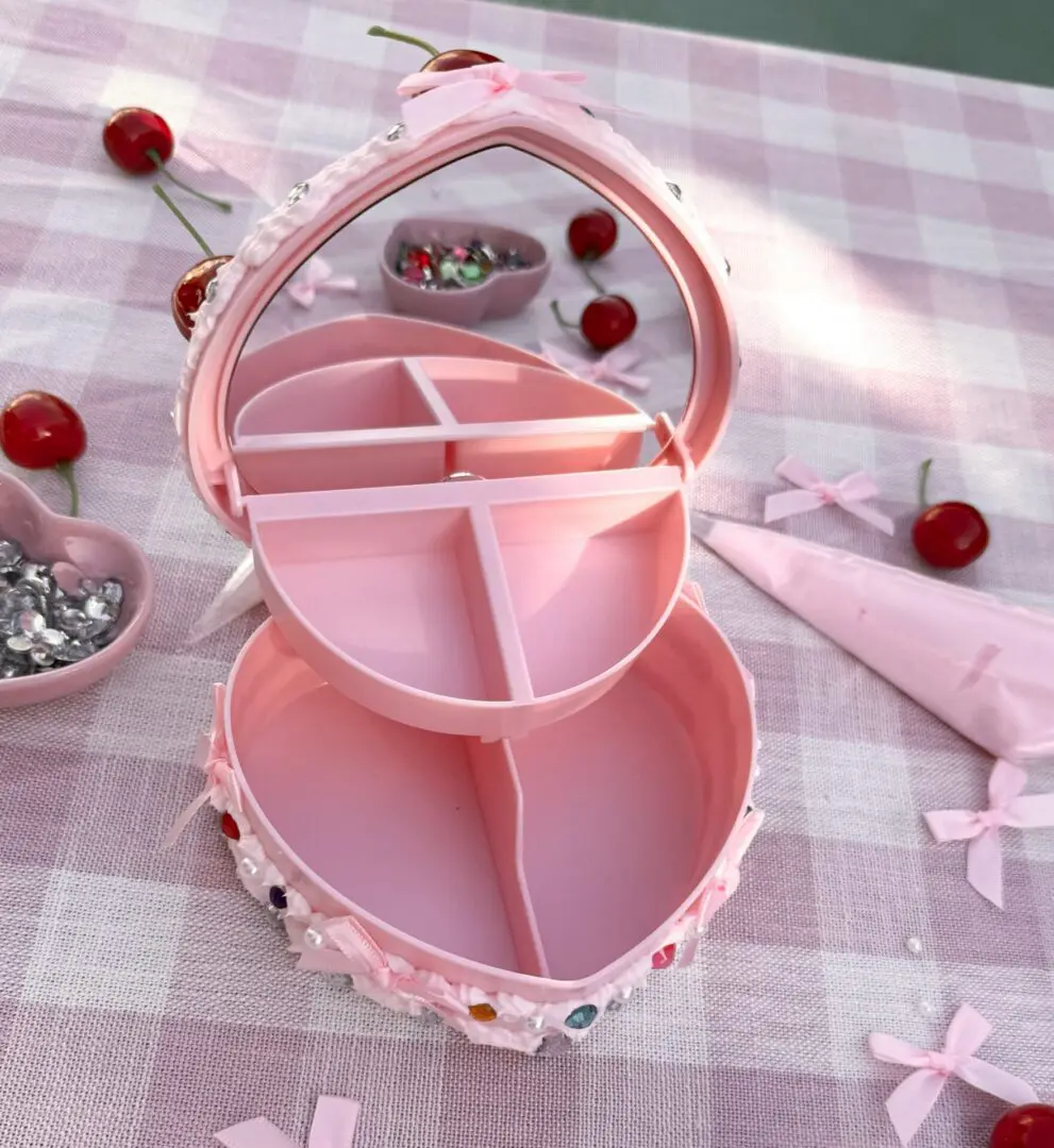 Open pink heart-shaped jewelry box with compartments