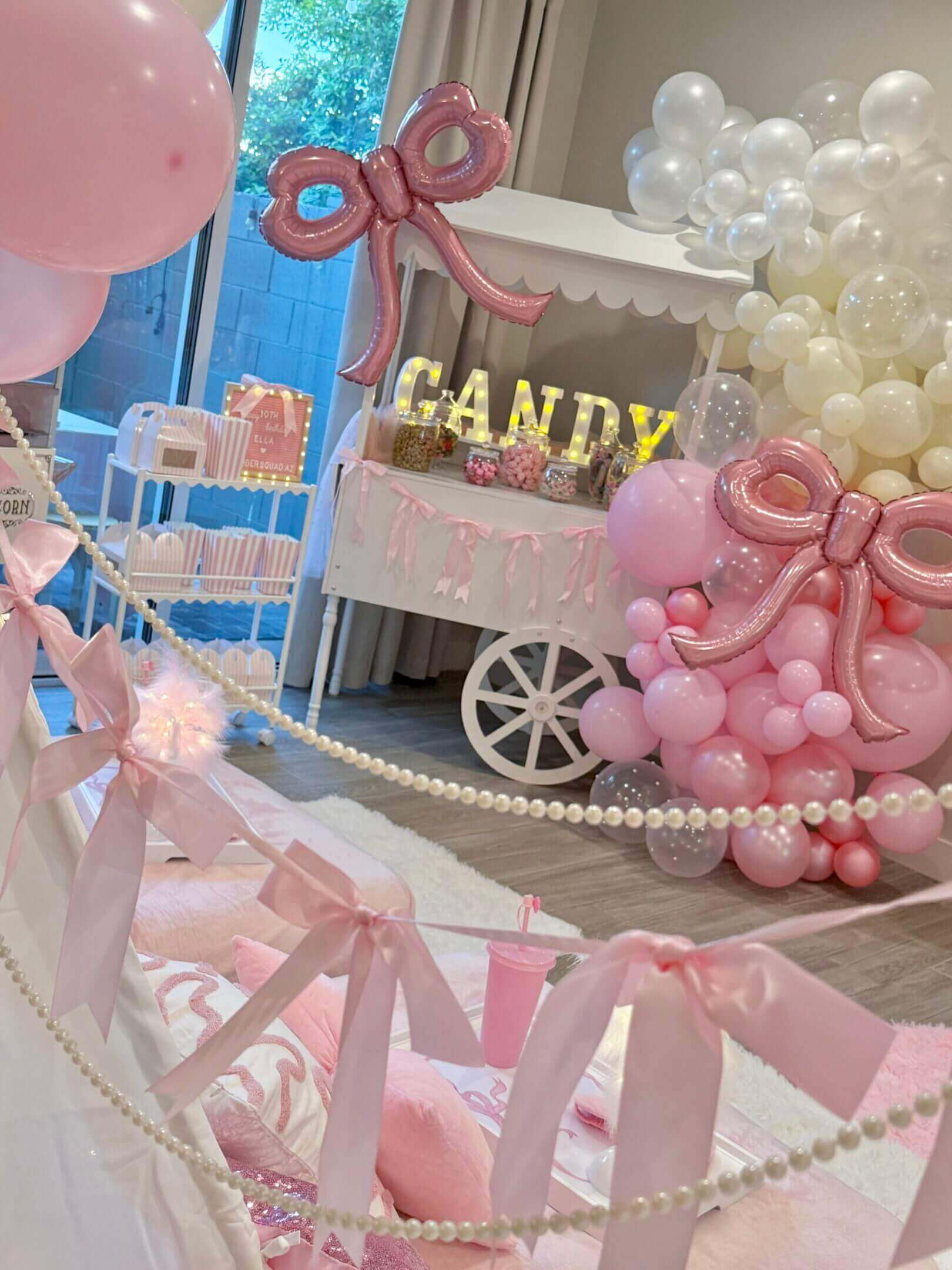 Pink candy cart party setup with balloons
